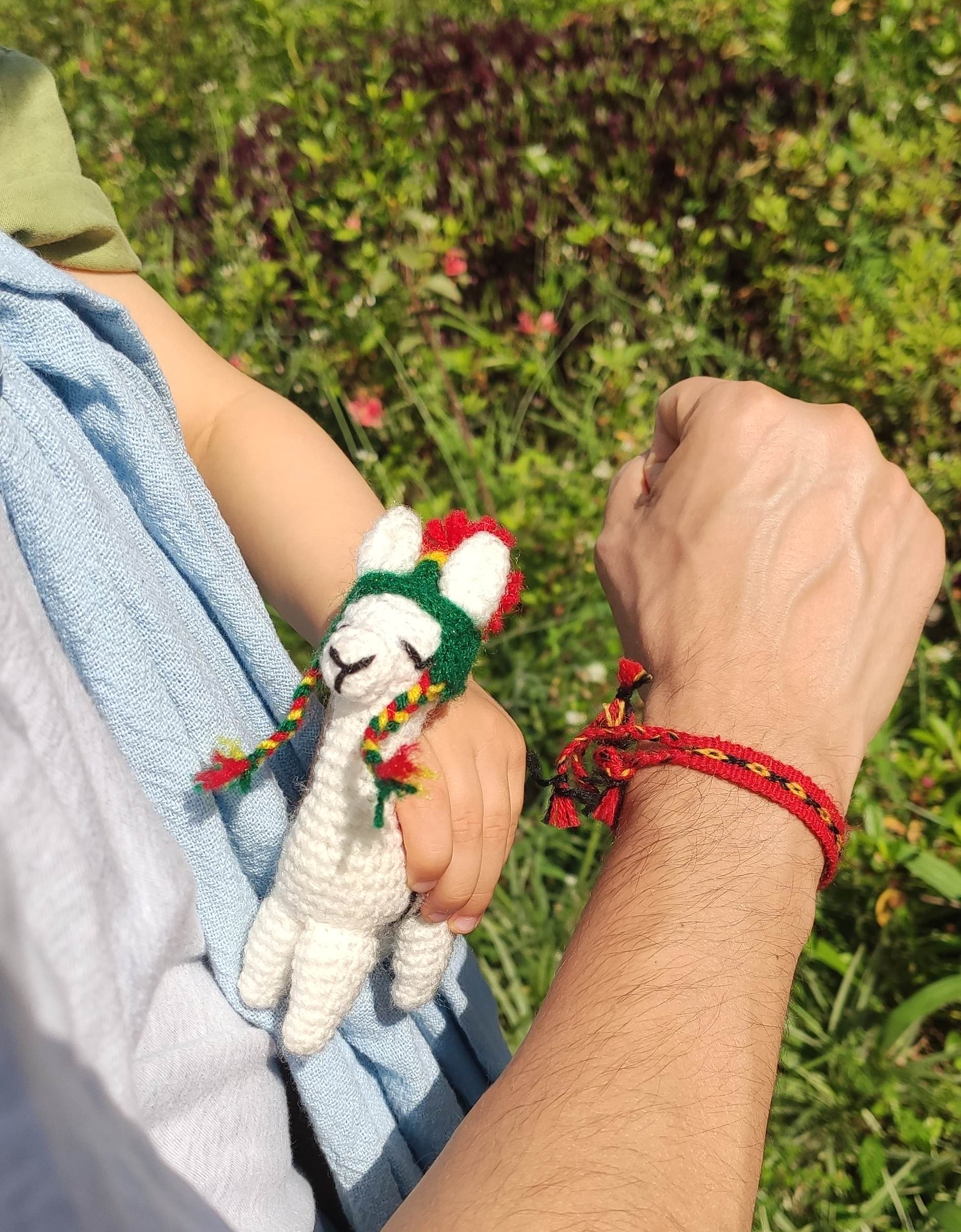 Bolivian themed bracelet on my wrist and toy llama on a baby's hand